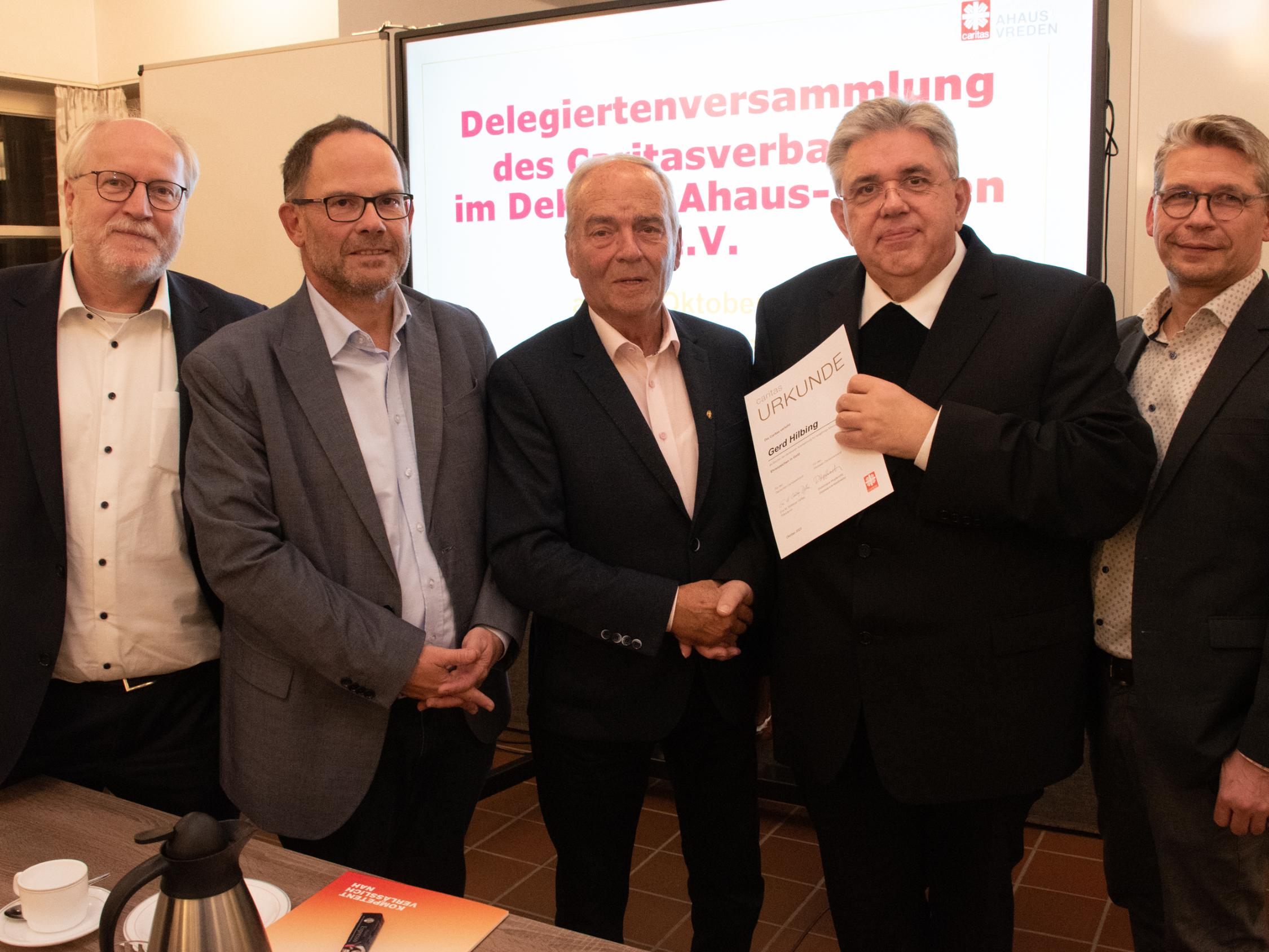 Gerd Hilbing (M.) erhielt das Ehrenzeichen in Gold des Caritasverbandes. Damit wurde das herausragende ehrenamtliche Wirken des Vredeners gewürdigt.  Das Foto zeigt den Geehrten, die Vorstände Matthias Wittland (l.), Hans-Peter Merzbach (2.v.l.) und Peter Schwack (r.) sowie den Vorsitzenden des Caritasrates, Pfarrer Stefan Scho (2.v.r.).
