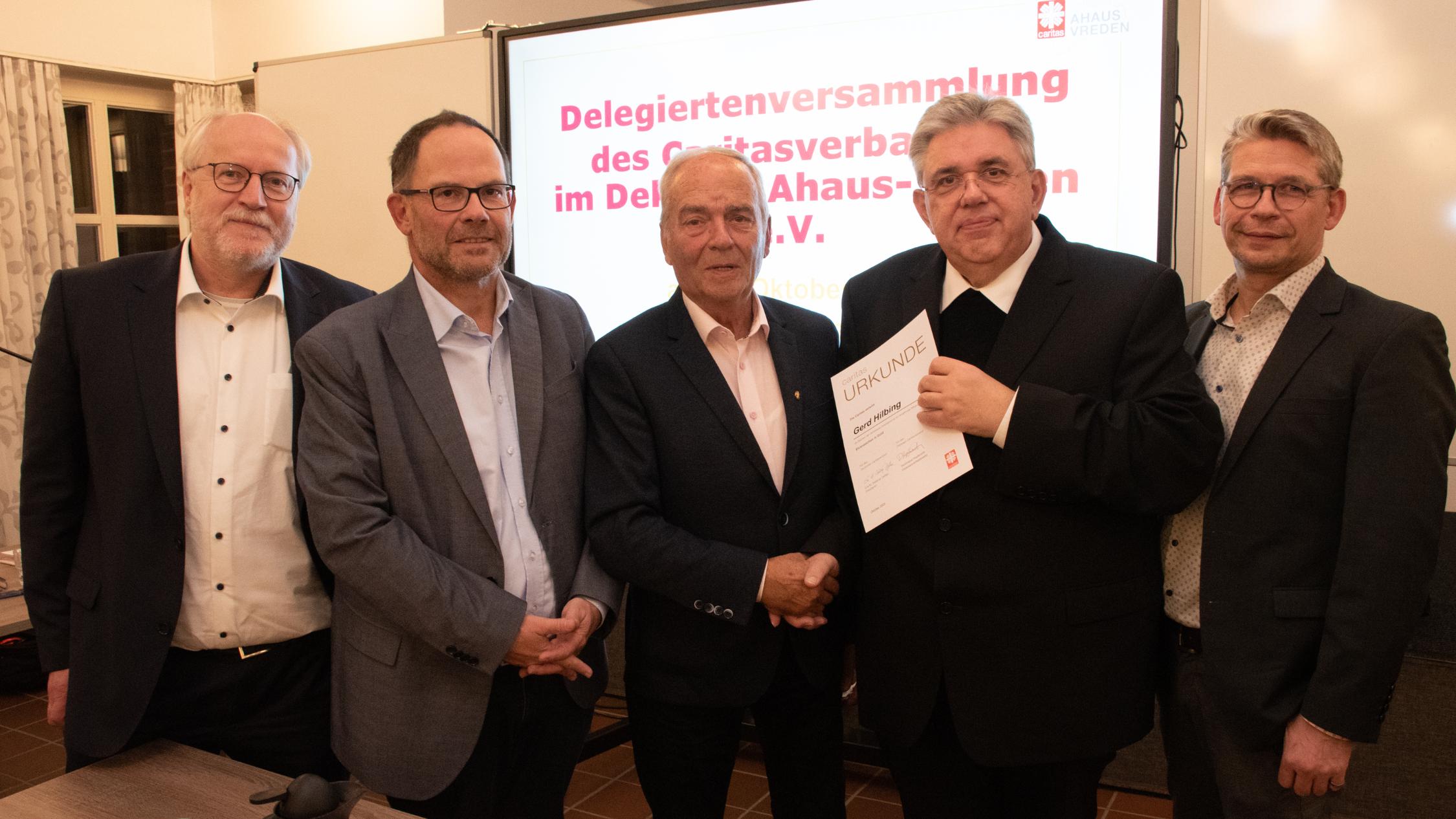 Gerd Hilbing (M.) erhielt das Ehrenzeichen in Gold des Caritasverbandes. Damit wurde das herausragende ehrenamtliche Wirken des Vredeners gewürdigt.  Das Foto zeigt den Geehrten, die Vorstände Matthias Wittland (l.), Hans-Peter Merzbach (2.v.l.) und Peter Schwack (r.) sowie den Vorsitzenden des Caritasrates, Pfarrer Stefan Scho (2.v.r.).