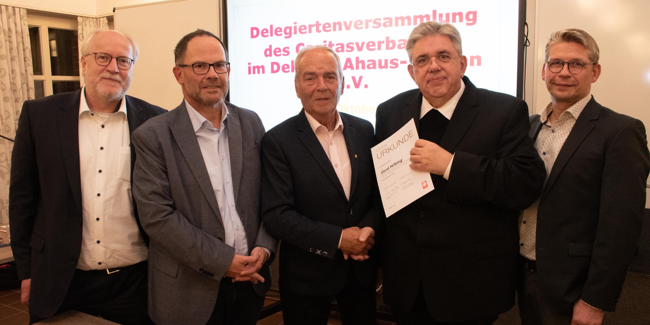 Gerd Hilbing (M.) erhielt das Ehrenzeichen in Gold des Caritasverbandes. Damit wurde das herausragende ehrenamtliche Wirken des Vredeners gewürdigt.  Das Foto zeigt den Geehrten, die Vorstände Matthias Wittland (l.), Hans-Peter Merzbach (2.v.l.) und Peter Schwack (r.) sowie den Vorsitzenden des Caritasrates, Pfarrer Stefan Scho (2.v.r.).