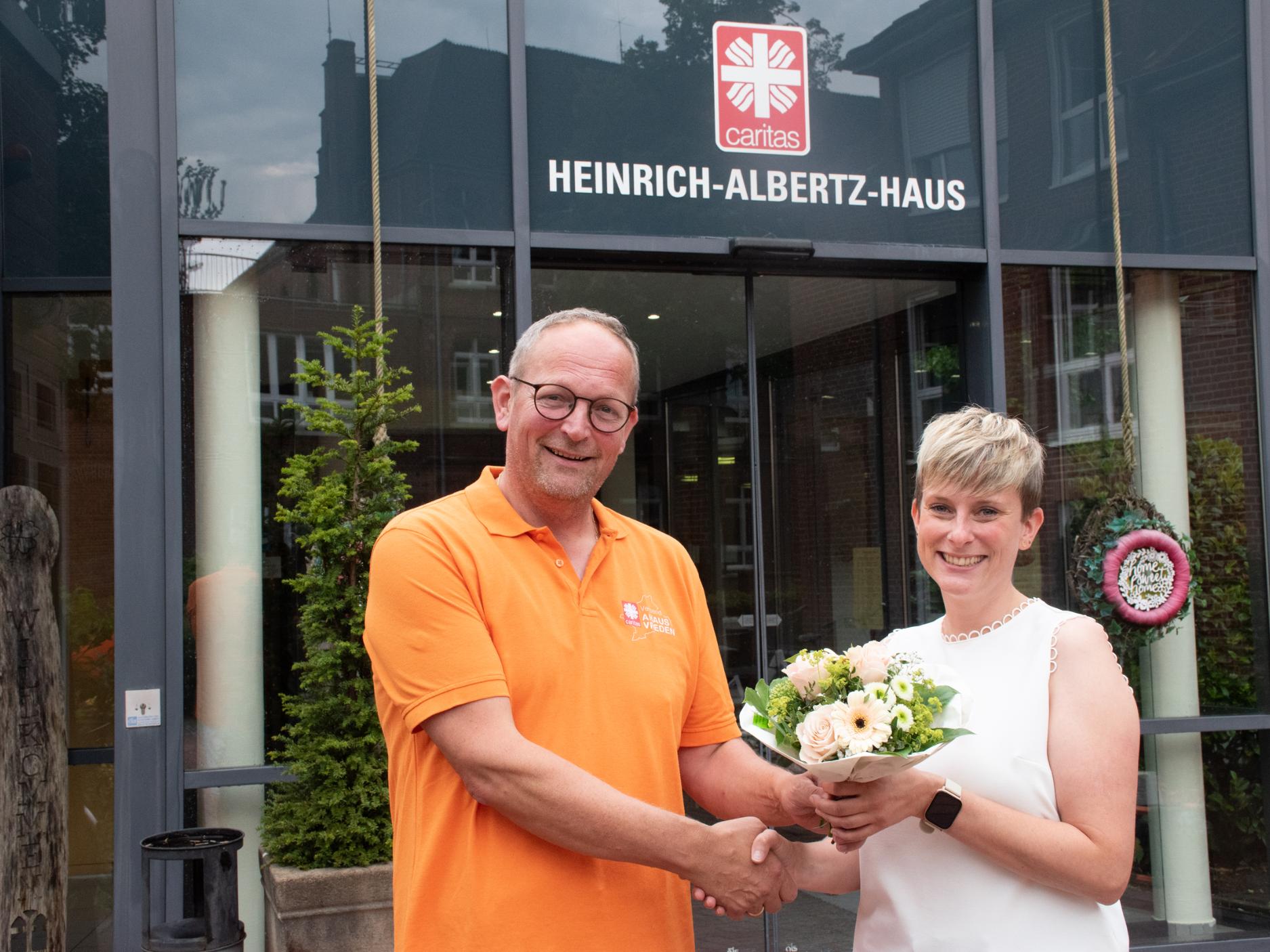 Blumengruß vom Vorgänger: Martin Overbeck hat die Leitung des Heinrich-Albertz-Hauses abgegeben. Linda Harking hat jetzt die Gesamtverantwortung inne.