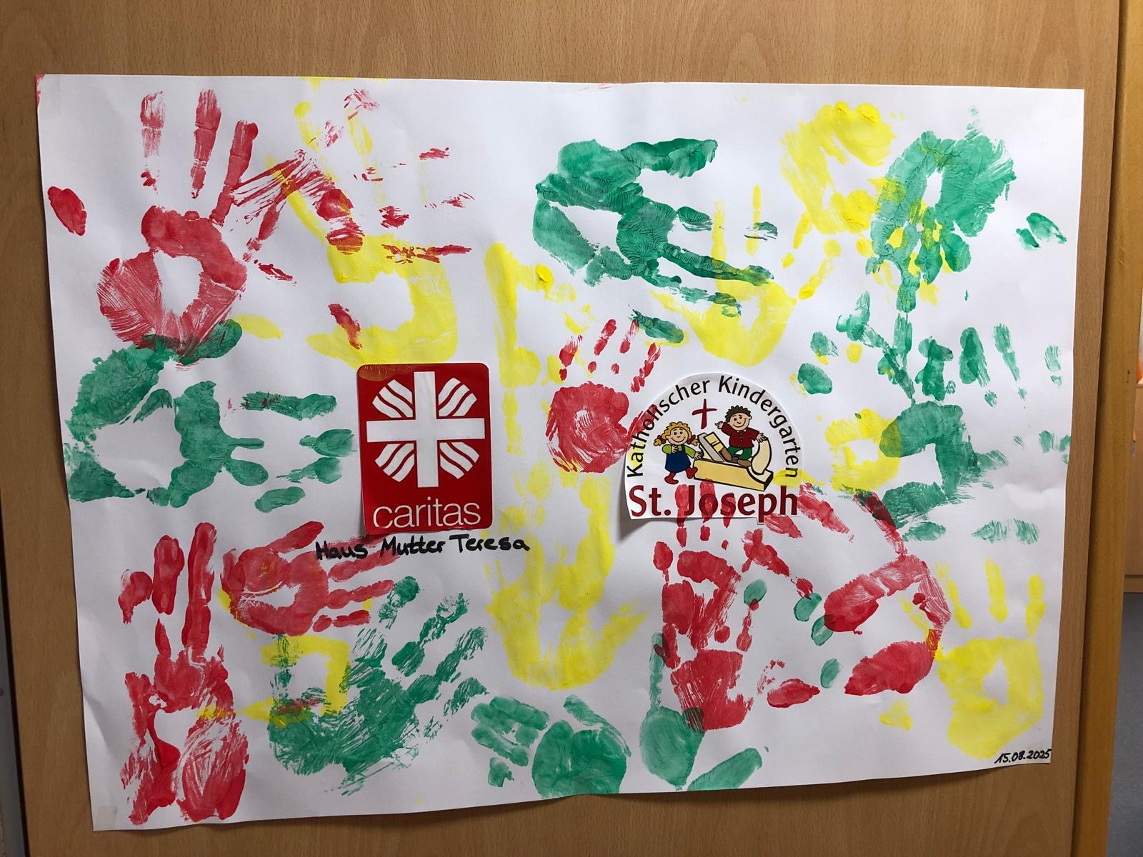 Rote, grüne und gelbe Handabdrücke der Tagesgäste auf einem Plakat.