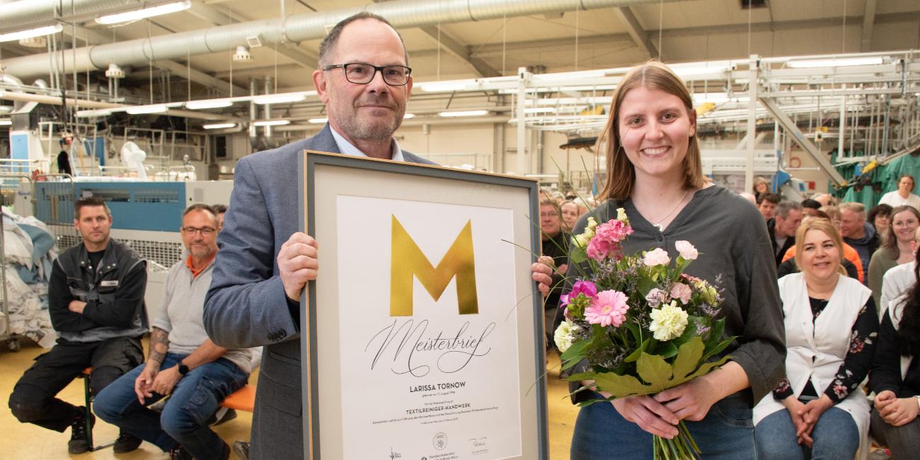 Caritas-Vorstand und GRB-Geschäftsführer Hans-Peter Merzbach mit dem Meisterbrief für Larissa Tornow.  Die 26-Jährige wurde im Rahmen der Betriebsversammlung geehrt.