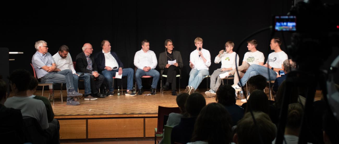 Moderiert von Dr. Nikolaus Schneider stellten sich neun Ahauser Lokalpolitiker auf dem Podium den Fragen der Schülerinnen und Schüler. (c) Bödding/CAV Moderiert von Dr. Nikolaus Schneider stellten sich neun Ahauser Lokalpolitiker auf dem Podium den Fragen der Schülerinnen und Schüler.
