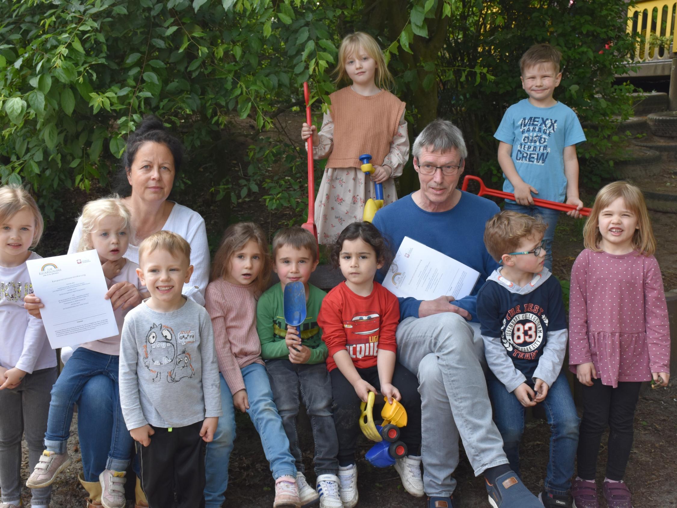 Birgit Hüsing-Hackfort (Familienzentrum), Dieter Homann (Caritas-Beratungsstelle) und Kinder aus dem Familienzentrum 'Zum Regenbogenland'.