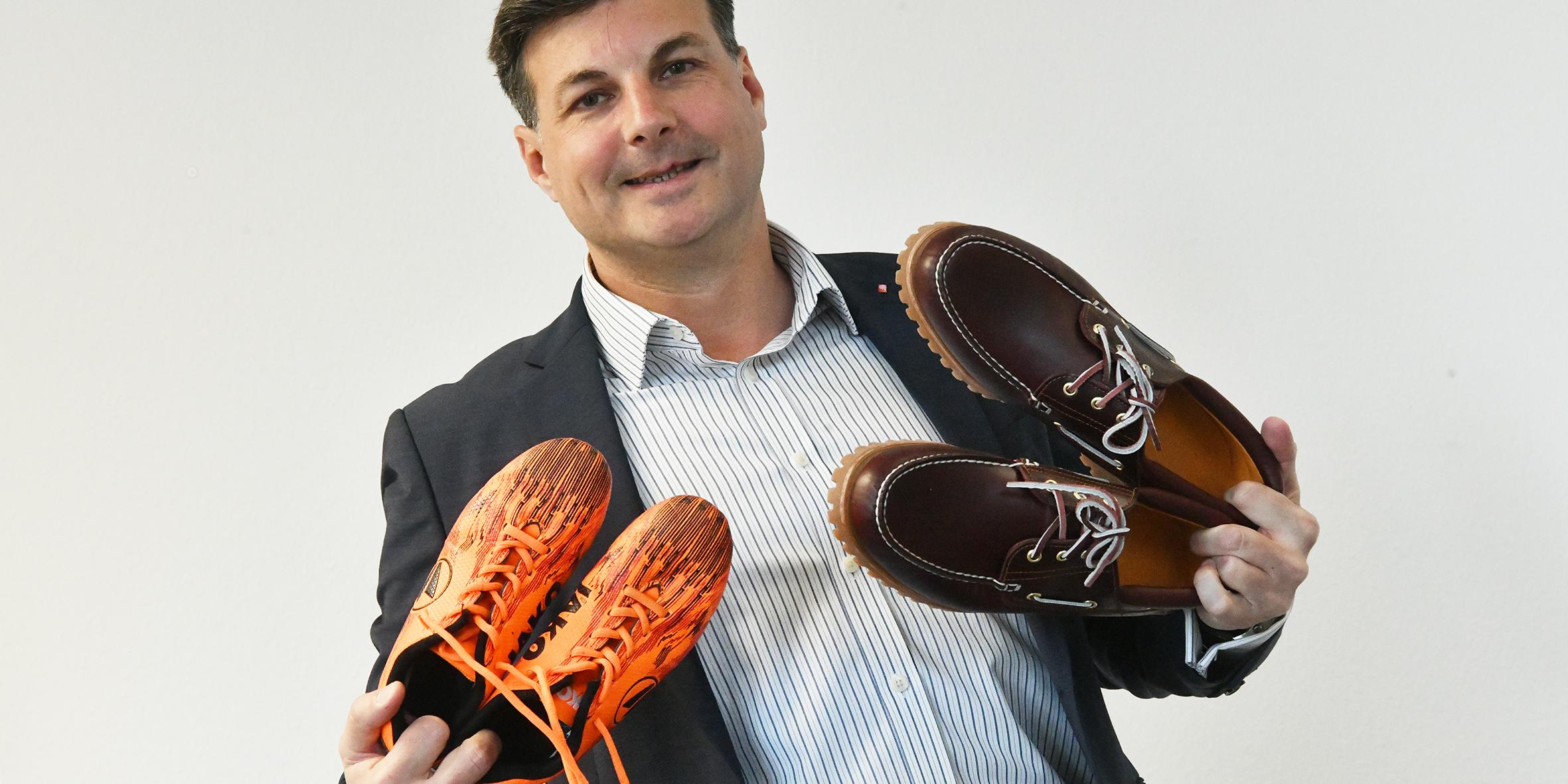 Schuhe unterschiedlicher Generationen sind Markenzeichen für das Verbindende der Jahreskampagne: Dominique Hopfenzitz mit den Fußballschuhen seines Sohnes und eigenen Schuhen.