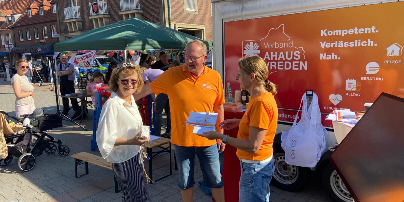 Zwei Mitarbeitende des Caritasverbandes informieren an ihrem Stand eine Frau über Möglichkeiten ehrenamtlicher Arbeit.