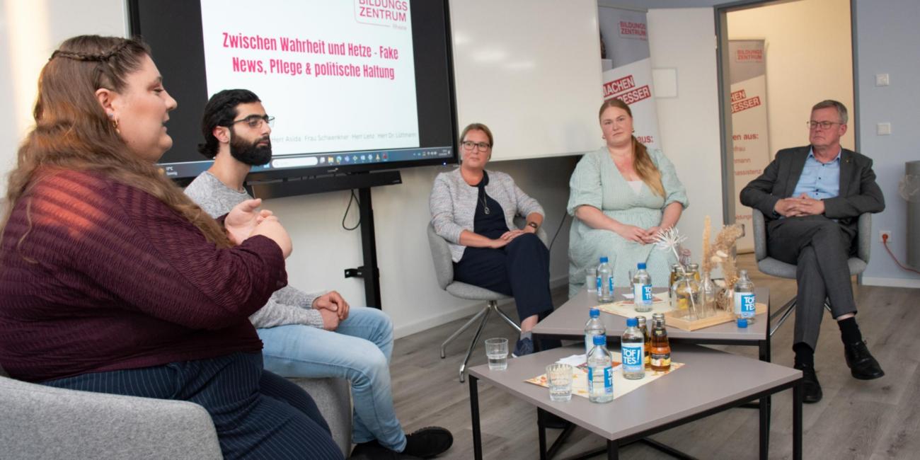 Auf dem Podium: Lucy Korbanek (Die Linke), Pflegefachmann Mosab Asida, Birgitt Overesch (CDU), Sarah Schwenkner (Bündnis 90/Die Grünen) und Bürgermeister Dr. Peter Lüttmann.