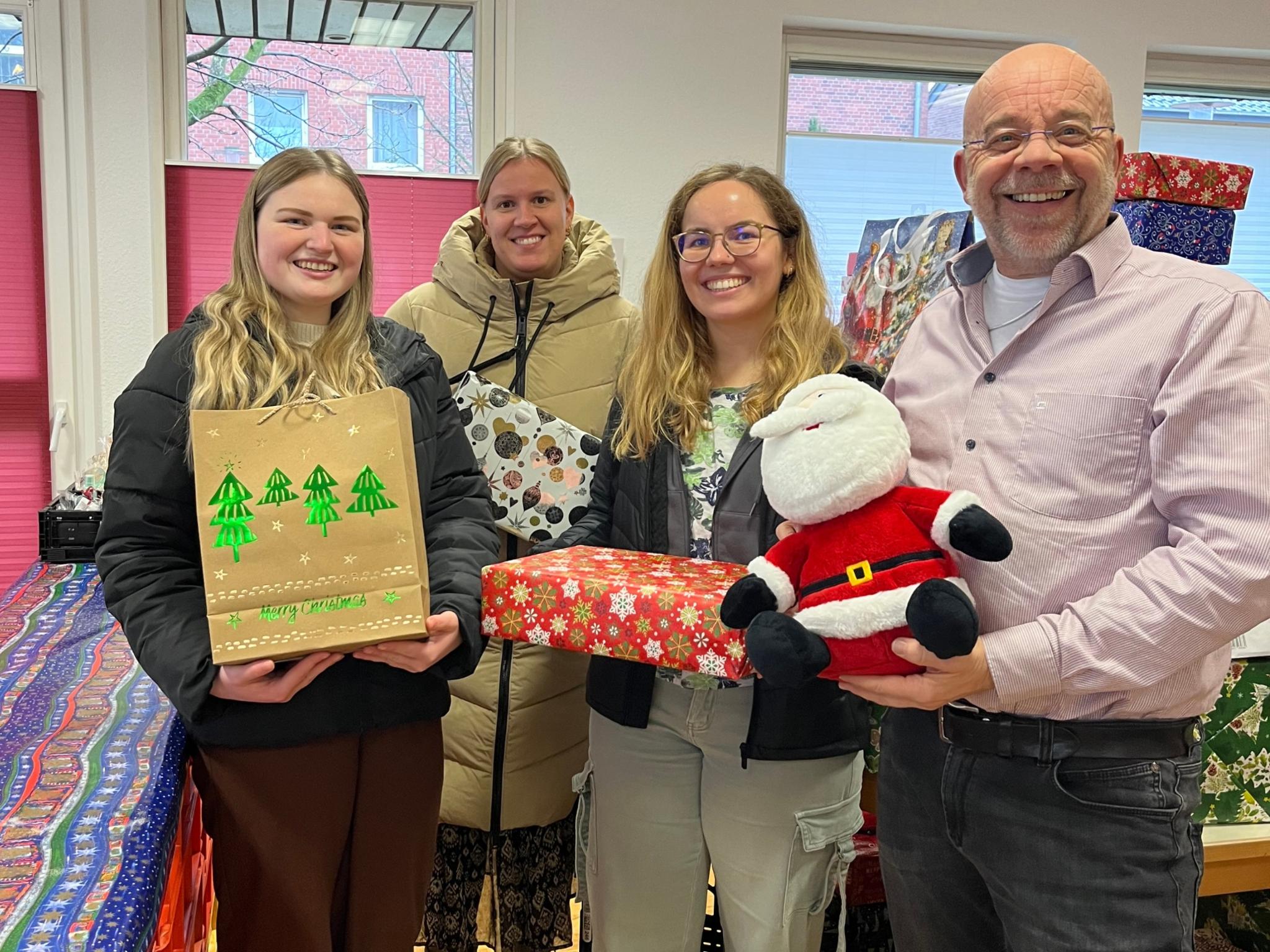Johannes Lügering (r.) von der Ahauser Tafel und die Auszubildenden Alessia Bone, Helena Reckert und Isabell Leesker bei der Übergabe der Weihnachtspäckchen.